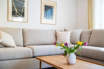 a living room with a couch and a table with flowers at Sea Eagles Landing by Revelstoke Vacations in Revelstoke