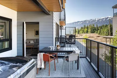 a patio with a table and chairs on a balcony at Sea Eagles Landing by Revelstoke Vacations in Revelstoke