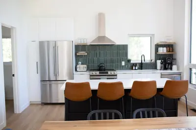 a kitchen with a refrigerator and a counter with chairs at Luxury Private Cabin In The Rockies in Golden
