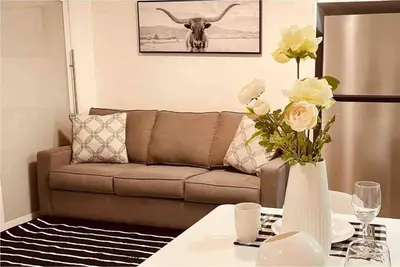 a living room with a couch and a table with flowers at Unit #204 Cozy Mountain View 2BR in Canmore Downtown in Canmore