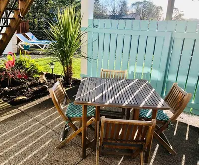 a wooden table and two chairs and a fence at Olympic Views - Cozy Modern 2Br Suite in Victoria