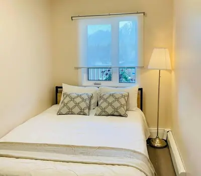 a bedroom with a white bed with a window at unit #303 Mountain view 1BR in Canmore DownTown in Canmore