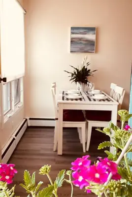 a white table and chairs in a room with flowers at unit #303 Mountain view 1BR in Canmore DownTown in Canmore