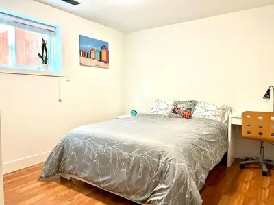 a bedroom with a bed and a desk and a window at Newly Renovated Walkout Basement in Vancouver with Separate Entrance in Vancouver