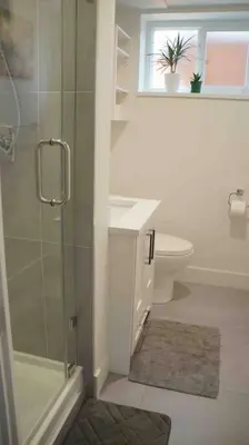 a bathroom with a shower and a toilet and a window at Newly Renovated Walkout Basement in Vancouver with Separate Entrance in Vancouver