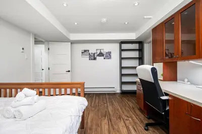 a bedroom with a bed and a desk and a chair at Gorgeous 4 Bedroom Garden Level Suite at Vancouver West & UBC in Vancouver