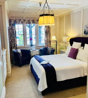 a bedroom with a large bed and a living room at The Latch Inn in Sidney