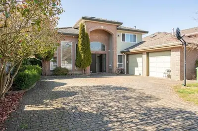 a brick house with a driveway in front of it at Master Bedroom with Two Queen Sized Bed in Richmond