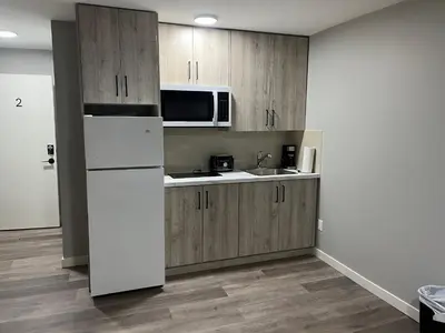 a kitchen with a white refrigerator and a microwave at Bethel hotel Elk Point in Elk Point