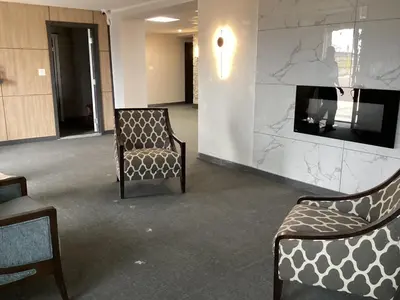 a waiting room with two chairs and a fireplace at Bethel hotel Elk Point in Elk Point