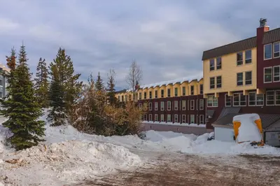 a school building with snow in front of it at The Ridge Ski-In Ski-Out Condo with Free Parking in Big White