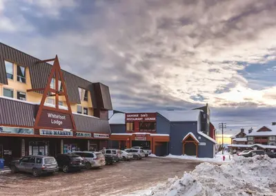 a group of buildings with cars parked in a parking lot at The Ridge Ski-In Ski-Out Condo with Free Parking in Big White