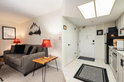 a living room with a couch and a table at The Maple Ski-in Ski-out 1 Bed with Hot Tub and Pool in Whistler