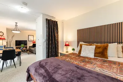a bedroom with a large bed and a living room at The Maple Ski-in Ski-out 1 Bed with Hot Tub and Pool in Whistler