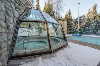 a glass dome with a hot tub in the snow at The Maple Ski-in Ski-out 1 Bed with Hot Tub and Pool in Whistler