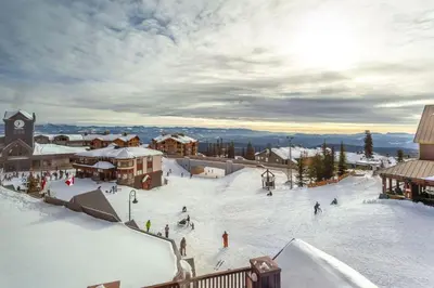 a ski resort with people skiing in the snow at The Fjall Ski-In Ski-Out Village Studio in Big White