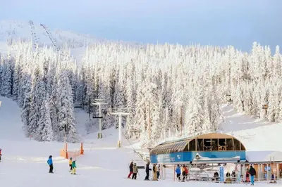 a group of people on a ski slope with a ski lift at The Fjall Ski-In Ski-Out Village Studio in Big White