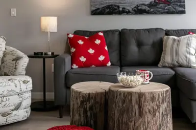 a living room with a couch and a tree stump table at Lovely 2 bedroom suite steps from The beach in Victoria