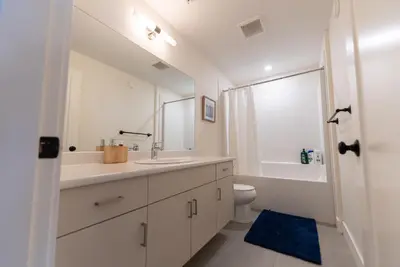 a white bathroom with a sink and a toilet at Mountain Retreat with Views, Hot Tub, Games & AC in Chilliwack