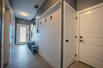 a hallway with a white wall and a door at Mountain Retreat with Views, Hot Tub, Games & AC in Chilliwack