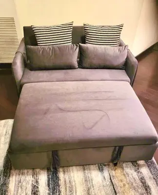 a couch with acovered ottoman in a living room at Luxury 2 Bedroom 1Pullout Kitchenette Grand Rockies Resort Hot Tub Pool Mountain View in Canmore