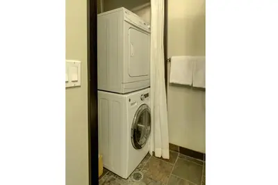 a washer and dryer in a small room at Luxury 2 Bedroom 1Pullout Kitchenette Grand Rockies Resort Hot Tub Pool Mountain View in Canmore
