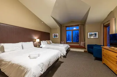 a hotel room with two beds and a television at Copper Horse Lodge in Golden