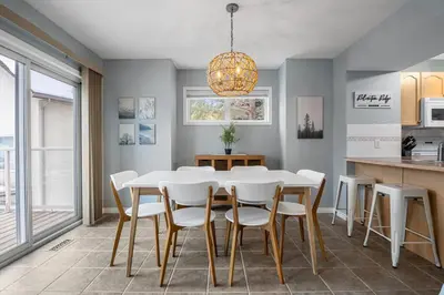 a dining room with a white table and white chairs at R&R Relaxation Ridge, Private Hot Tub, Spacious in Radium Hot Springs