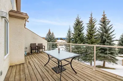 a wooden deck with a table on top of it at R&R Relaxation Ridge, Private Hot Tub, Spacious in Radium Hot Springs