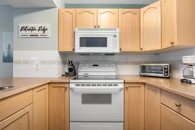 a kitchen with a white stove and a microwave at R&R Relaxation Ridge, Private Hot Tub, Spacious in Radium Hot Springs