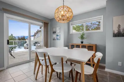 a dining room with a white table and chairs at R&R Relaxation Ridge, Private Hot Tub, Spacious in Radium Hot Springs