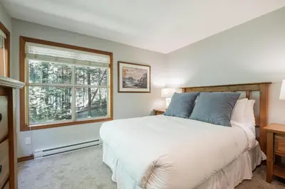 a bedroom with a bed and a window at Arrowhead Point by Outpost Whistler in Whistler