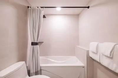a bathroom with a white toilet and a shower curtain at Arrowhead Point by Outpost Whistler in Whistler