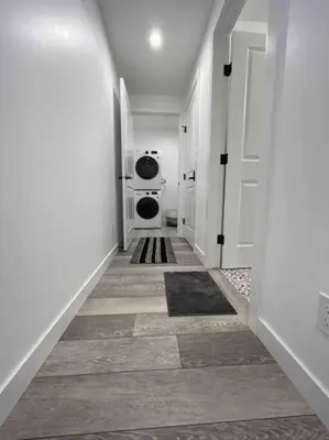 a hallway with a washer and dryer in a house at 2BR Suite, Private Entry, Full Kitchen, Washer & Dryer, Free Parking, Smart TV with Netflix, High-Speed Wi-Fi, Self Check-In, Near Banff National Park in Calgary