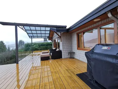 a screened in deck with a view of a house at Deep Cove Stunning Waterfront Whole House in North Vancouver