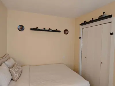 a bedroom with a bed and a shelf on the wall at sweet home in Richmond
