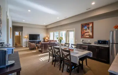 a kitchen and living room with a table and chairs at Sunrise Valley Suite in West Kelowna