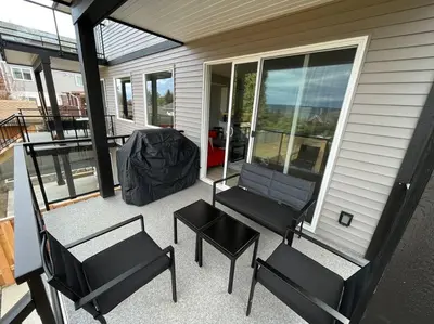 a screened porch with two chairs and a table at Ocean View Oasis in Campbell River