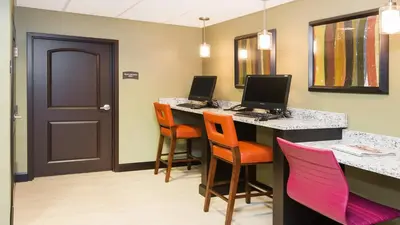 a room with two computers on a desk with chairs at Staybridge Suites West Edmonton by IHG in Edmonton