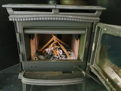 a fireplace with a pile of debris in it at Mountain House of Wonder in Qualicum Beach