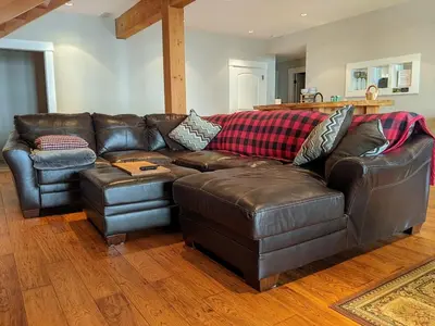 a brown leather couch in a living room at Mountain House of Wonder in Qualicum Beach