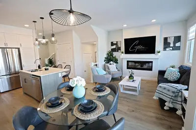 a kitchen and living room with a table and chairs at Stylish Home with AC, 3 King Beds, Garage, Disney in Edmonton