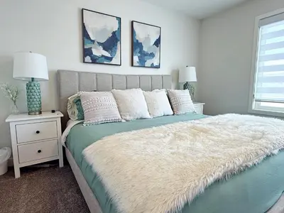 a bedroom with a large bed with a white blanket at Stylish Home with AC, 3 King Beds, Garage, Disney in Edmonton