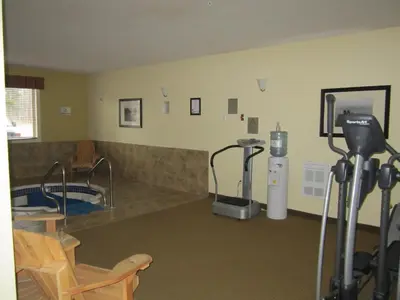 a room with a gym with a treadmill and a machine at Trend Mountain Hotel & Conference Centre in Tumbler Ridge