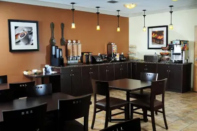 a restaurant with a table and chairs and a counter at Trend Mountain Hotel & Conference Centre in Tumbler Ridge