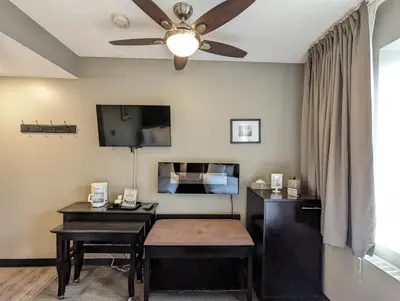 a living room with a desk and a ceiling fan at King Edward Hotel in Banff
