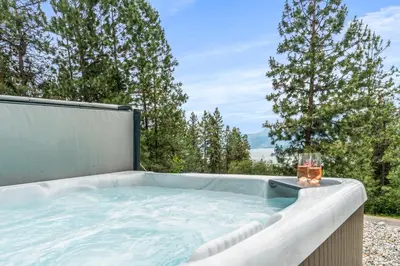a jacuzzi tub with a view of trees at Heaven's Haven in Vernon