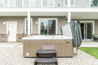 a hot tub with a chair next to a house at Heaven's Haven in Vernon
