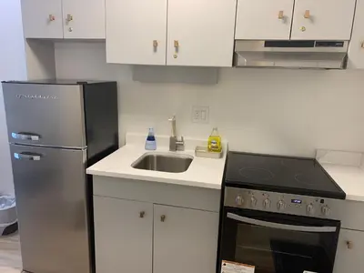 a kitchen with a stainless steel refrigerator and a sink at Destination Inn Cache Creek in Cache Creek