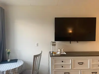 a flat screen tv on a wall above a dresser at Destination Inn Cache Creek in Cache Creek
